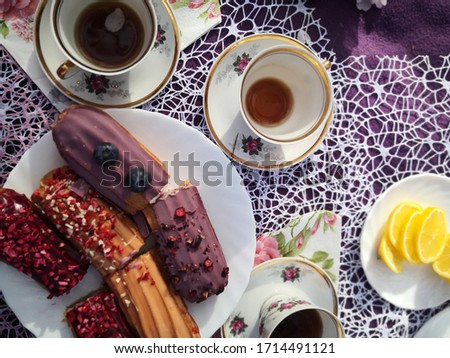 Romantic spring picnic in pink colors under the sakura. English breakfast tea and eclairs.