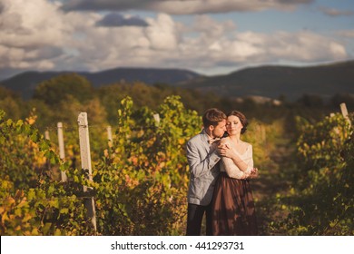 Romantic and stylish caucasian couple standing in the beautiful vineyard at sunset. Love, relationships, romance, happiness concept. - Powered by Shutterstock