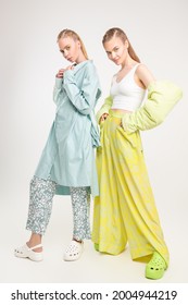 Romantic Summer Style. Two Beautiful Fashion Models Girls Pose In Elegant Summer Clothes And Clogs. Full Length Studio Portrait On A White Background. Fashion. 