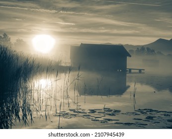 Romantic sunrise reflection  on lake Kochelsee against boathouses. Early summer morning view, Bavaria, Germany. BW, Black and white, - Powered by Shutterstock