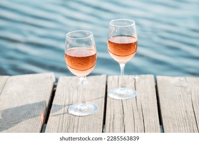 Romantic sunset dinner on the beach. Table honeymoon set for two with luxurious food, glasses of rose wine drinks in a restaurant with sea view. Summer love, romance date on vacation concept. - Powered by Shutterstock