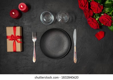 Romantic table setting in rustic style on black table decorated with roses bouquet and red candles flat lay. Romantic holidays valentine's day or date in restaurant - Powered by Shutterstock