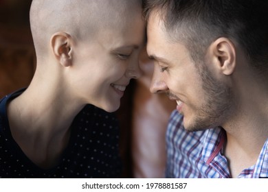 Romantic touch of foreheads of sweet young couple fighting against girlfriends cancer. Smiling faces of husband and wife talking close to each other. Love, intimacy, oncology concept. Close up