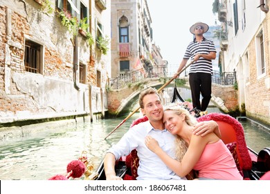 Romantic travel couple in Venice on Gondole ride romance in boat happy together on travel vacation holidays. Romantic young beautiful couple sailing in venetian canal in gondola. Italy, Europe.