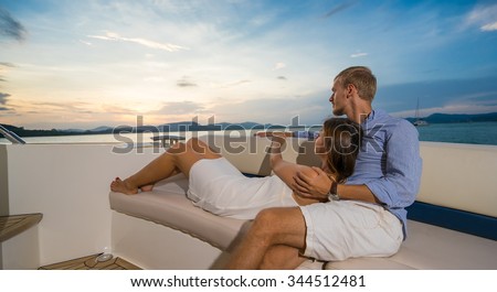 Romantic vacation . Beautiful couple  looking in sunset  from the yacht