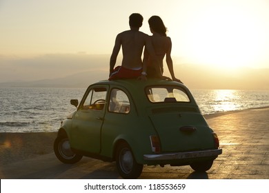 Romantic Vacation: Couple At Sundown On The Beach With Car