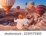 Romantic vacation Happy traveler couple watching sunrise with hot air balloons in Cappadocia Turkey travel.
