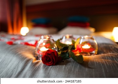 Romantic Valentines Day evening. Romantic night. Rose and candles on bed.