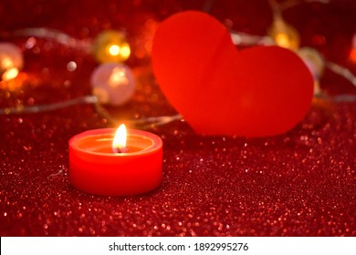 Romantic Valentine's Day. Lit scented candles and red heart on bright sparkling background with bokeh effect. Romantic dinner decoration. - Powered by Shutterstock