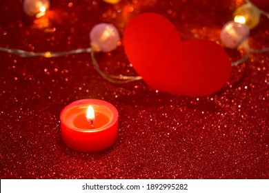 Romantic Valentine's Day. Lit scented candles and red heart on bright sparkling background with bokeh effect. Romantic dinner decoration. - Powered by Shutterstock