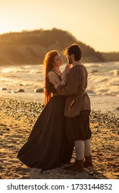 Romantic viking's reenactment couple at sunset on the beach and mountains background 