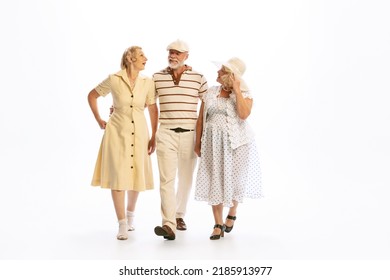 Romantic Walks. Handsome Senior Man And Two Charming Women In Vintage Retro Style Outfits Isolated On White Background. Concept Of Relations, Family, 1960s American Fashion Style And Art.