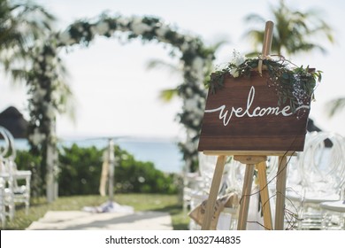 Romantic Wedding Ceremony On The Beach. Sign Welcome.