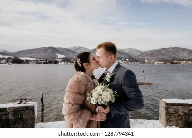 Romantic Wedding Moment, Couple Of Newlyweds Portrait, Bride And Groom Posing Near The Lake. Winter Wedding