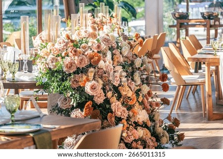  Romantic Wedding Table Setting with Sunset Glow and Floral Centerpiece. An elegant wedding table adorned with blush and peach florals, glowing in soft evening sunlight.