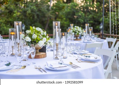 Romantic Wedding Table Top Layout Table Spread no people tropical location with gold cutlery white table cloth and scenic view of sunset with copy space tablescape