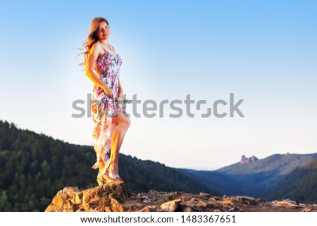 romantic woman in summer dress on top of a mountain