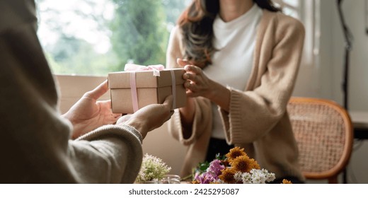 Romantic young asian couple embracing giving present in living room at home. Fall in love. Valentine concept - Powered by Shutterstock