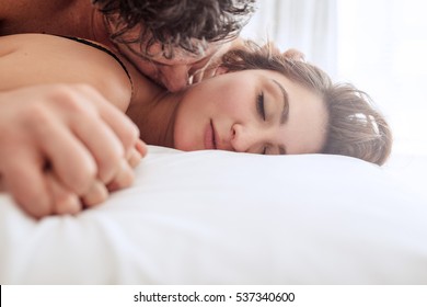Romantic young couple in bed. Man and woman in bed making love.