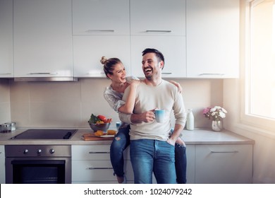 Romantic young couple cooking together in the kitchen,having a great time together. - Shutterstock ID 1024079242