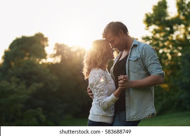 Romantic Young Couple Dancing Together Outside At Sunset