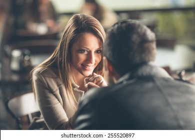 Romantic Young Couple Dating And Flirting At The Bar, Staring At Each Other's Eyes