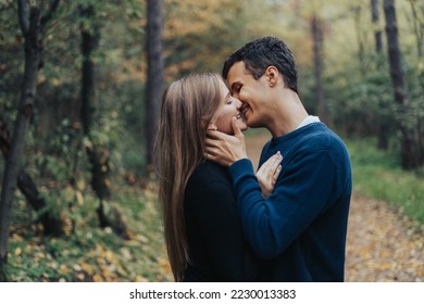 Joven pareja romántica besándose en un bosque
