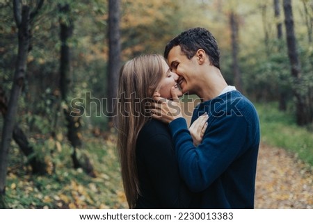 Romantic young couple kissing in a forrest