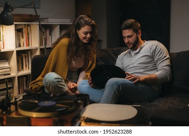 Romantic Young Couple Listening To A Music On Record Player At Home