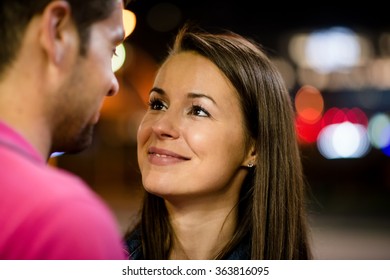 Romantic Young Couple On Date In Street At Night Looking To Their Eyes