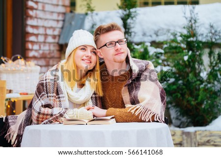 Romantic young couple sharing biscuit at outdoor restaurant
