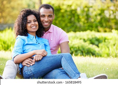Romantic Young Couple Sitting In Garden