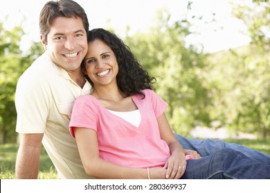 Romantic Young Hispanic Couple Relaxing In Park