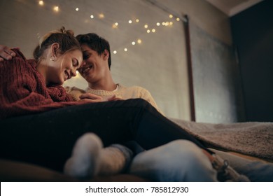 Romantic Young Man And Woman Sitting Together On Couch At Home. Cozy Couple Relaxing In Living Room.