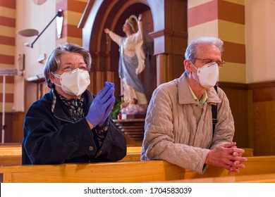 ROME - APRIL 11, 2020: A Couple Prays On Knees In The Suburban Church Of San Giuseppe During The Total Closure Of The City Taking Advantage Of The Few Hours Of Opening Of The Church