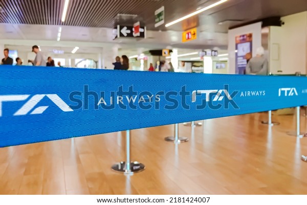 Rome, ITA, July 2022: blue belt barrier with\
white ITA Airways airlines logo. ITA Airways is the Italian flag\
carrier. Travel and airport\
security