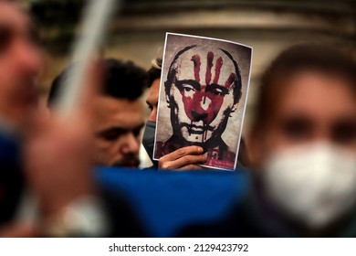 ROME, ITALY, 25.02.2022: Putin's bloody face on a poster is shown during Ukrainian protesters with candles gather in Piazza del Campidoglio in Rome, against the war operations of Russia in Ukraine