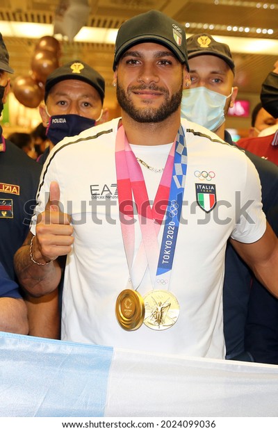 Rome, Italy - 9.8.2021:  Marcell Jacobs, an\
Italian athlete who won two gold medals at the Tokyo 2020 Olympics\
games, returns to Italy at the Fiumicino airport celebrated by his\
mother and friends.