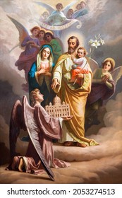 ROME, ITALY - AUGUST 31, 2021: The  painting of St. Joseph and Holy Family the church Chiesa del Sacro Cuore di Gesu probably by Giuseppe Rollini (1832).