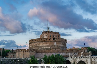 Rome Italy Castel SantAngelo Mausoleum Of Hadrian Evening View With Ponte Sant’Angelo Pedestrian Bridge Visible And Puffy Clouds Above.