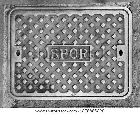 Rome, Italy - Characteristic iron manhole cover in the streets of the city of Rome, with the inscription SPQR (Senatus Populusque Romanus, 