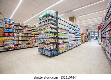 ROME, ITALY. December 05, 2018: Lanes of shelves with goods products inside a MA supermarket in Italy in Rome. Variety of packaged food, snacks and more. Shelves full and tidy.