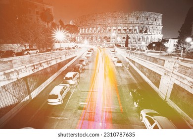 Rome, Italy. Highlight View Of Colosseum Also Known As Flavian Amphitheatre In Evening Night Time. Night Traffic Light Trails Near Famous World Landmark. All Colors Except Red, Pink And Yellow Reduced