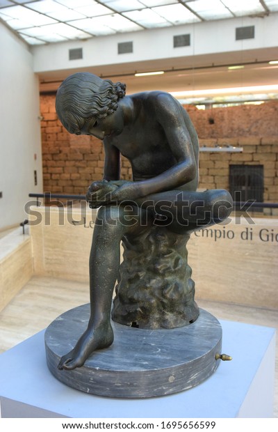 Rome, Italy - January 18,\
2020: boy with thorn, also called Fedele (Fedelino) or Spinario,\
roman bronze statue in Palazzo dei Conservatori, Capitoline\
museum
