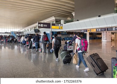 Rome, Italy - june 3, 2020: First passengers after Covid 19 pandemic lockdown in Rome Fiumicino Airport. Line of people waiting for boarding in airport keeping one meter social distance.