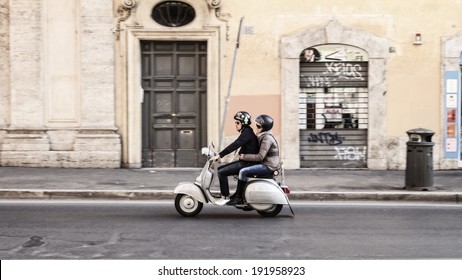ROME, ITALY - MARCH 29 2014: Young adult man and woman on a scooter in the in the old town on MARCH 29 2014 in Rome in Italy