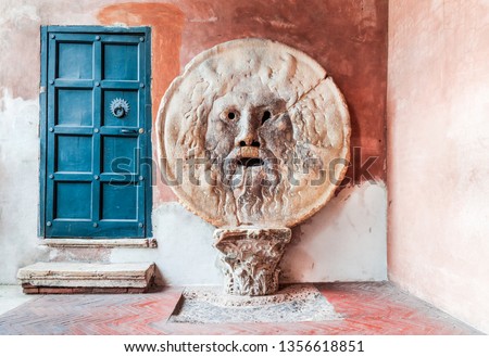 Rome, Italy. The Mouth of Truth (La Bocca della Verita) carved from Pavonazzo marble, in the portico of the church of Santa Maria in Cosmedin.