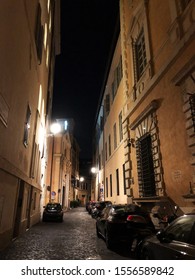 Rome, Italy - September 10 2018: A Narrow Italian Street At Night With Parked Cars, No People, Lit By Lanterns