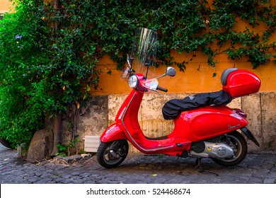 Rome, Italy - September 23, 2016: Red Vespa scooter parked on old street in Rome, Italy