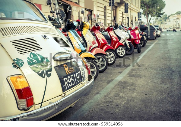 ROME - JANUARY\
07: Old car and retro scooters on January 07, 2017 in Rome.\
Scooters are the symbol of Rome - most popular historical travel\
place of the Italy and the\
world.